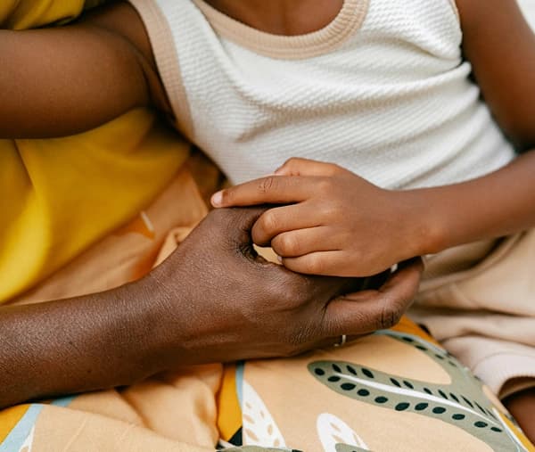 Two people holding hands in a gesture of support